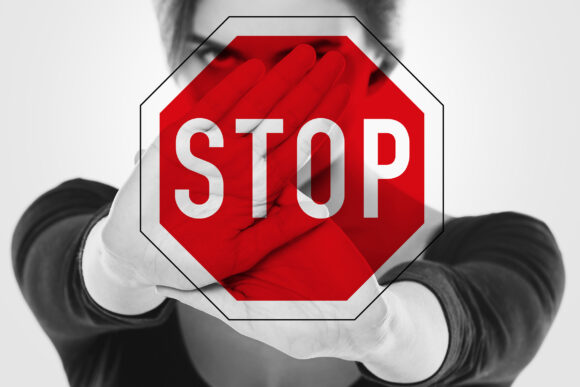 Angry woman and stop sign. Women's rights - stop discrimination, harassment and violence against women.
